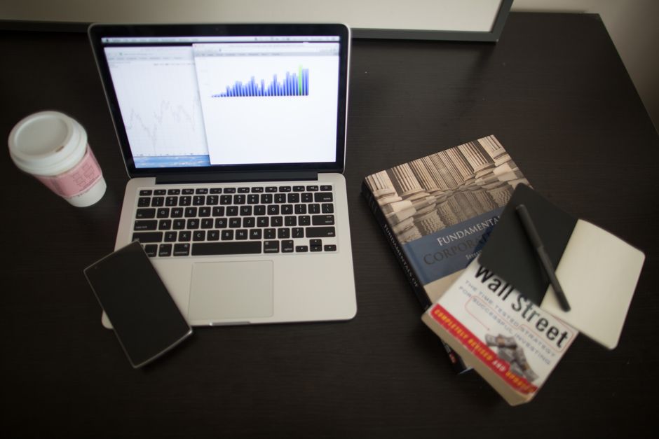 Top view of a desk with laptop, charts, books