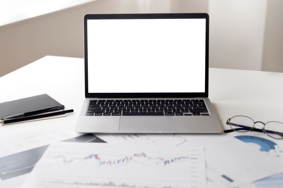 Open laptop with financial documents on a desk, ideal for business and technology themes.